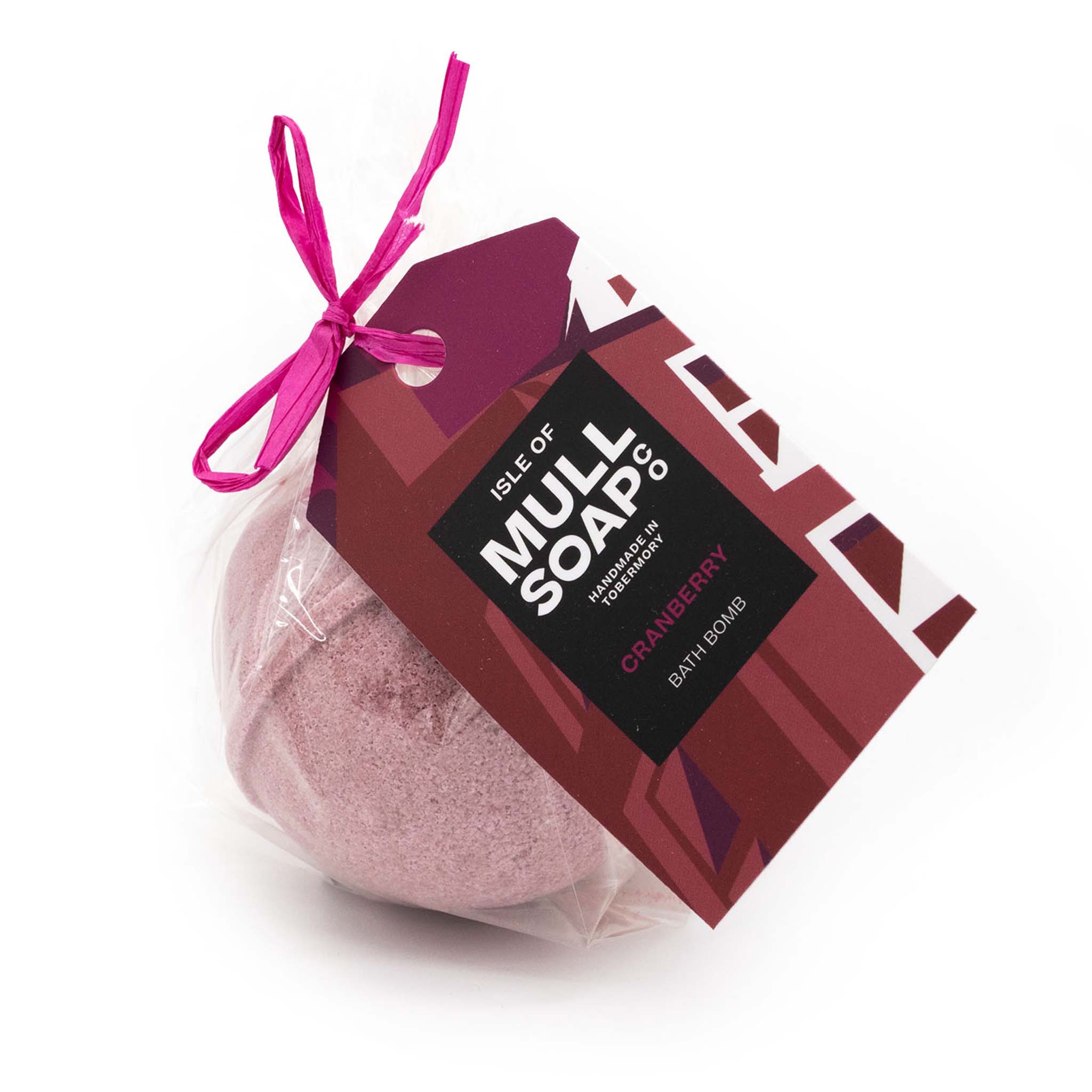  red coloured round cranberry bath bomb presented as a gift in a bag with coloured tag and bow. Handmade by the Isle of Mull soap co in Tobermory, Scotland. 