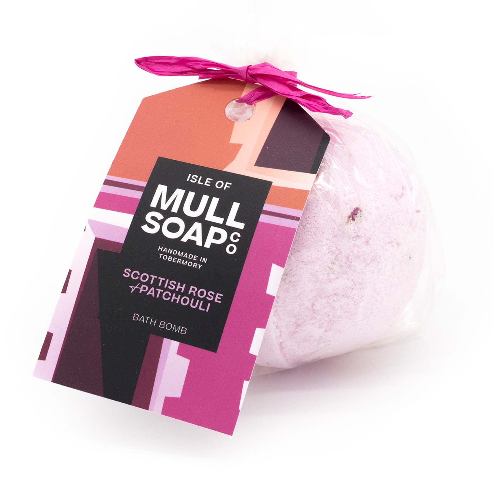 pink coloured round Scottish rose and patchouli bath bomb presented as a gift in a bag with coloured tag and bow. decorated with rose petals. Handmade by the Isle of Mull soap co in Tobermory, Scotland. 
