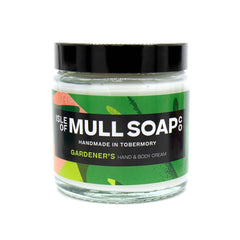 A glass jar with black lid. colourful green label design, filled with Gardener's hand and body cream handmade in Tobermory by the Isle of Mull soap co. 