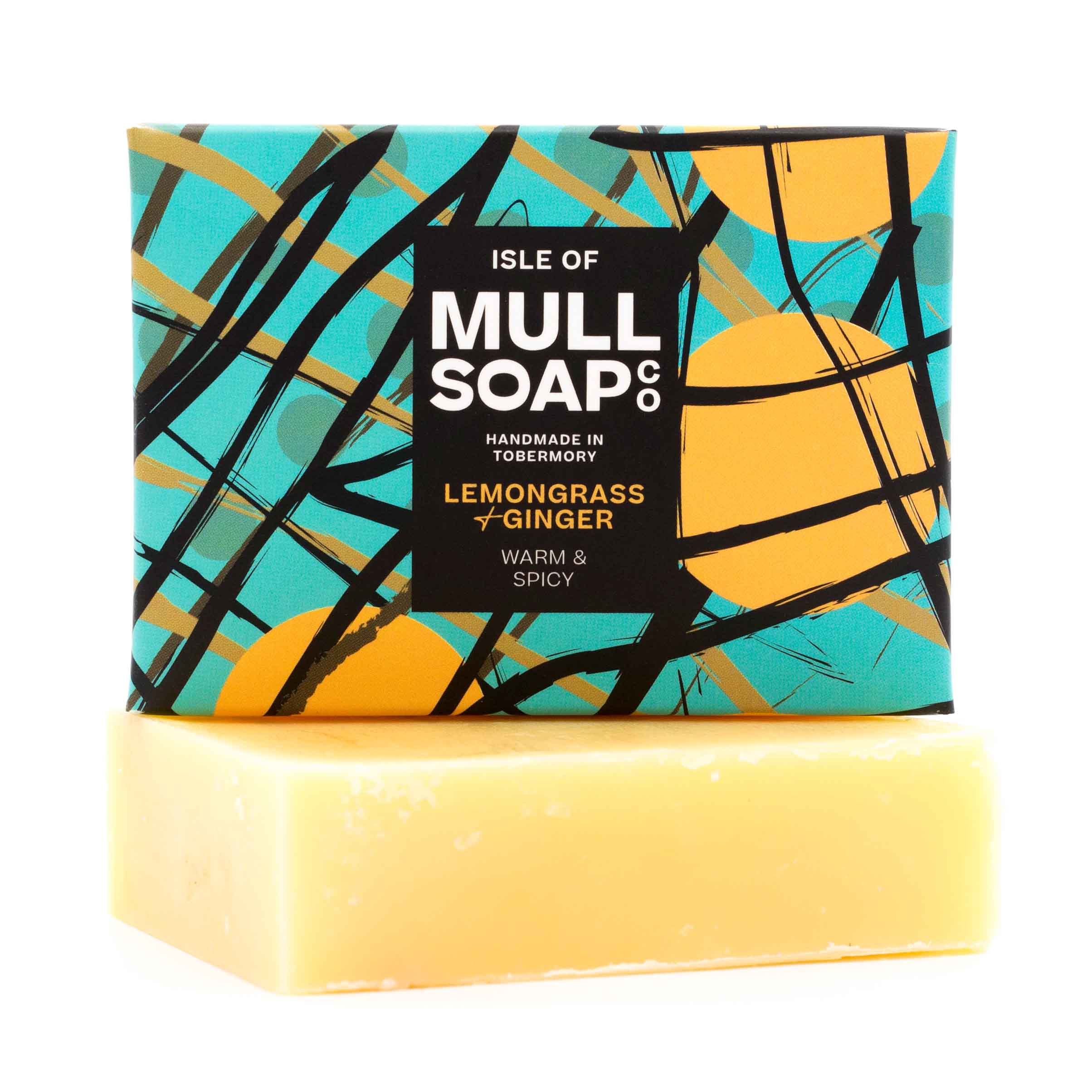 a lemongrass and ginger soap box sitting on the soap bar. The box design is green with yellow buoys and black fishing nets. The soap is described as warm and spicy. Handmade in Tobermory by the Isle of Mull soap co.  