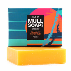 an orange and patchouli box sitting on top of the soap bar. The box is blue with a bright orange buoy design. The soap is described as warm and juicy. Handmade in Tobermory by the Isle of Mull soap co.  