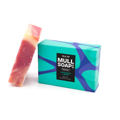a lavender and mint soap box sitting next to the swirled pink soap bar. The box is a blue and green design. The soap is described as bright, minted floral. Handmade in Tobermory by the Isle of Mull soap co.  