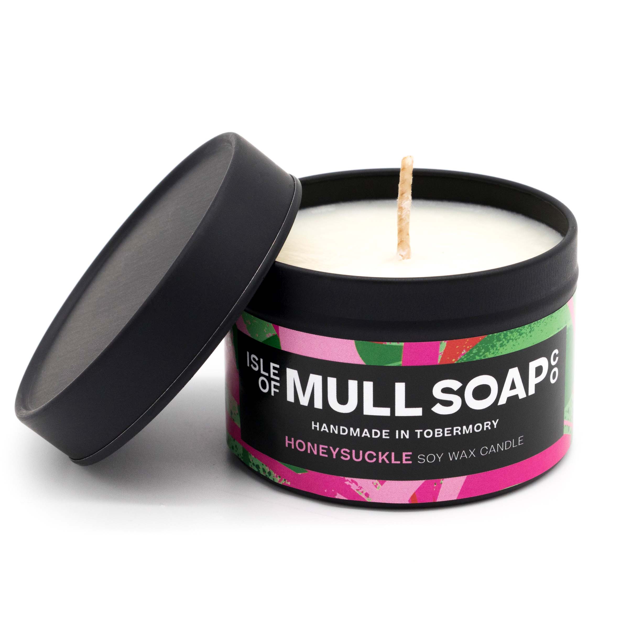 A black tin and lid with colourful pink floral label. honeysuckle soy candle handmade in Tobermory by the Isle of Mull Soap Co 